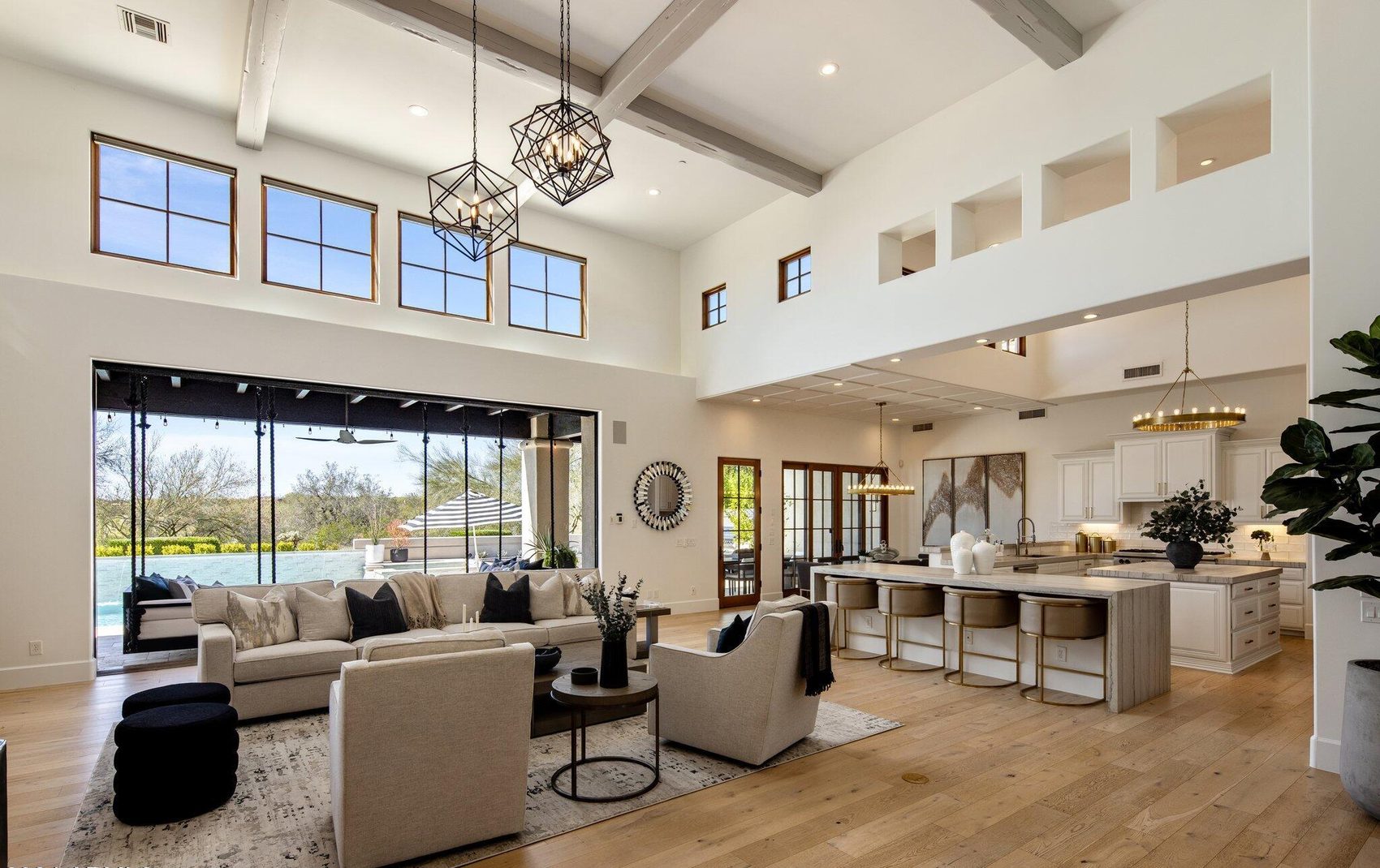 The same great room after — bright white walls, white oak floors, fully furnished Desert Modern