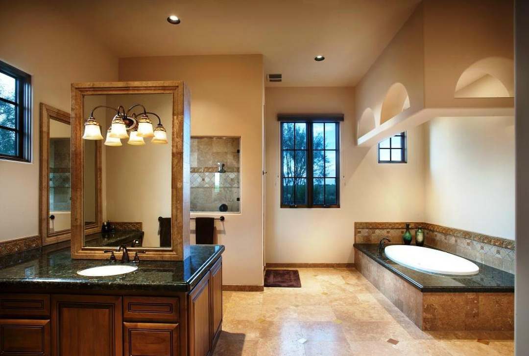 The primary bath before — dated travertine and traditional finishes