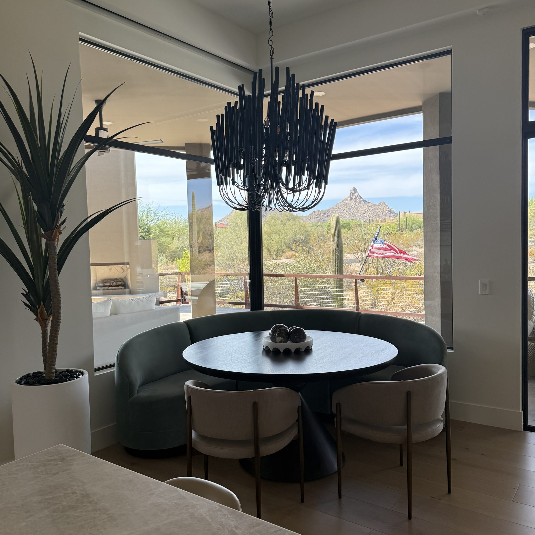 Dining nook with a sculptural black chandelier and McDowell Mountain views